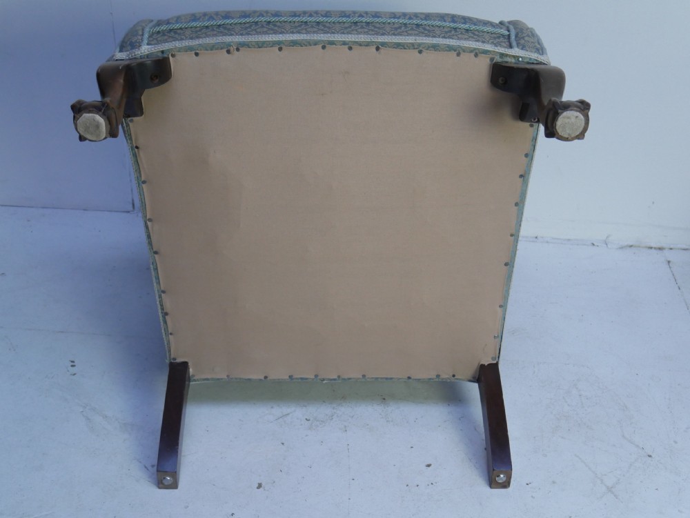 A high-backed wing armchair upholstered in patterned blue damask fabric with a deep buttoned backrest and carved wood cabriole front legs. View IX