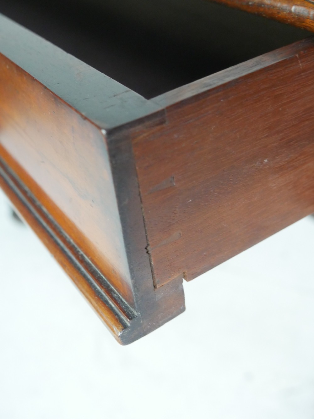 A mahogany writing desk featuring a dark leather inset top, two frieze drawers, and a turned stretcher connecting carved trestle end supports. View VII