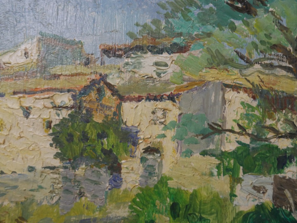 An impressionist oil painting depicting a sunny French village landscape with stone buildings and trees, presented in a dark wooden frame. View V
