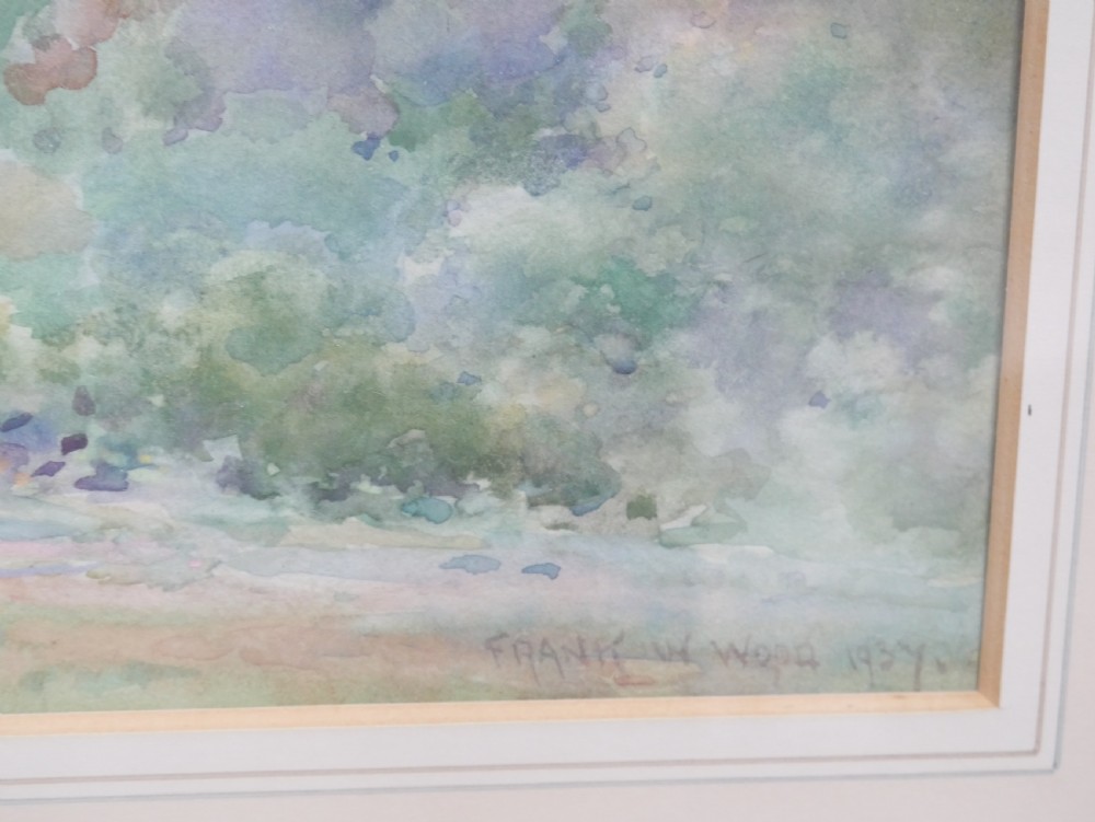 A framed watercolour landscape painting by Frank Wood depicting Bamburgh Castle on the Northumberland coast under a pale sky. View V