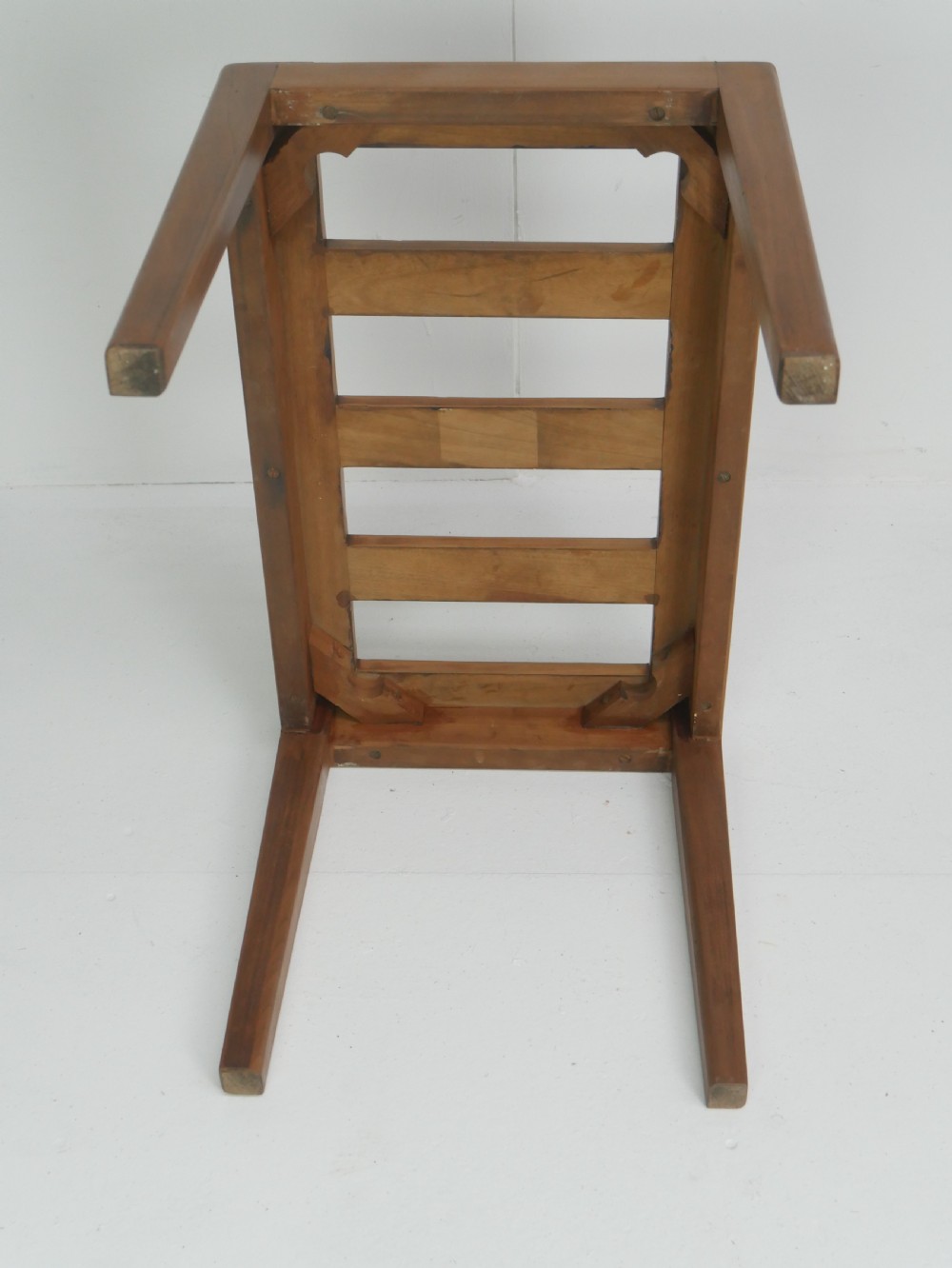 A warm brown wooden luggage rack featuring a slatted rectangular top resting on four square tapered legs. View IV