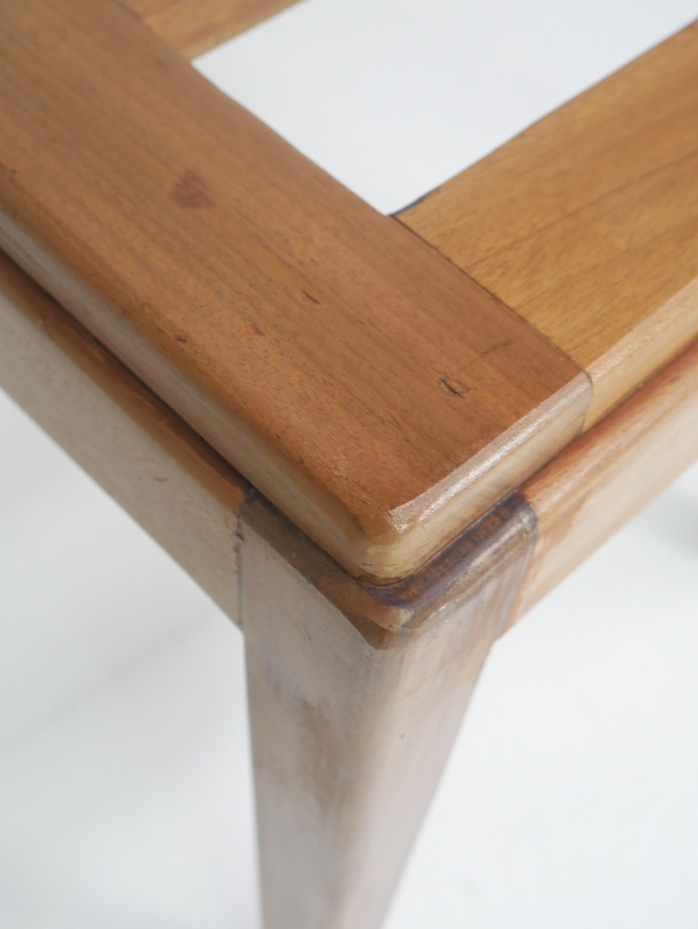 A warm brown wooden luggage rack featuring a slatted rectangular top resting on four square tapered legs. View V