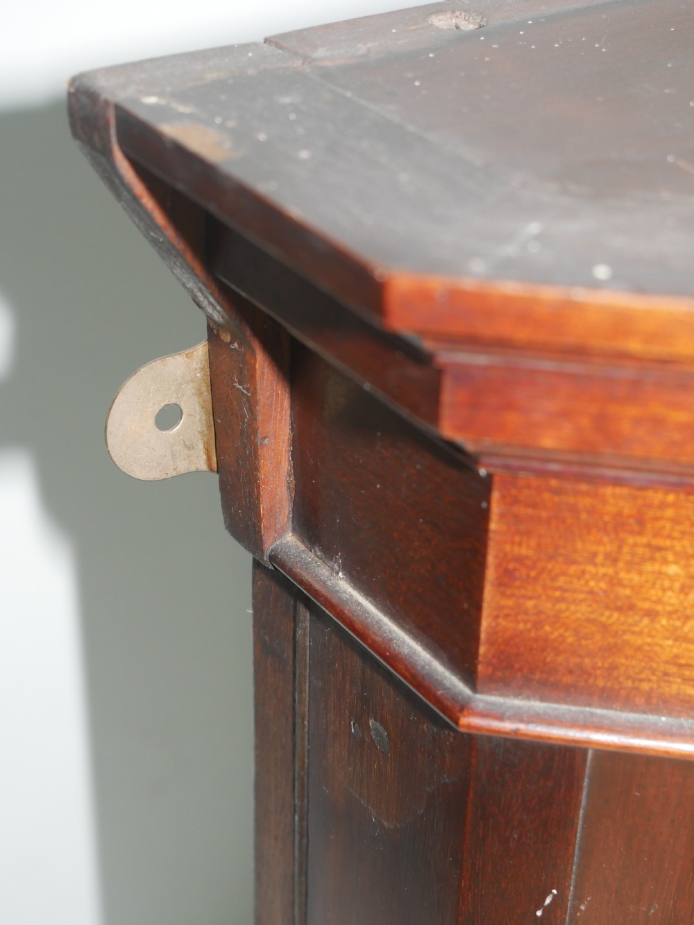 A wall-mounted mahogany display cabinet featuring glazed doors, canted side panels, decorative wood marquetry on the upper frieze, and a brass key escutcheon. View III