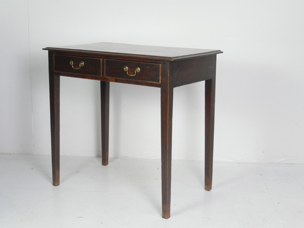 A dark mahogany Georgian side table featuring two front drawers with brass swan-neck handles and square tapered legs.