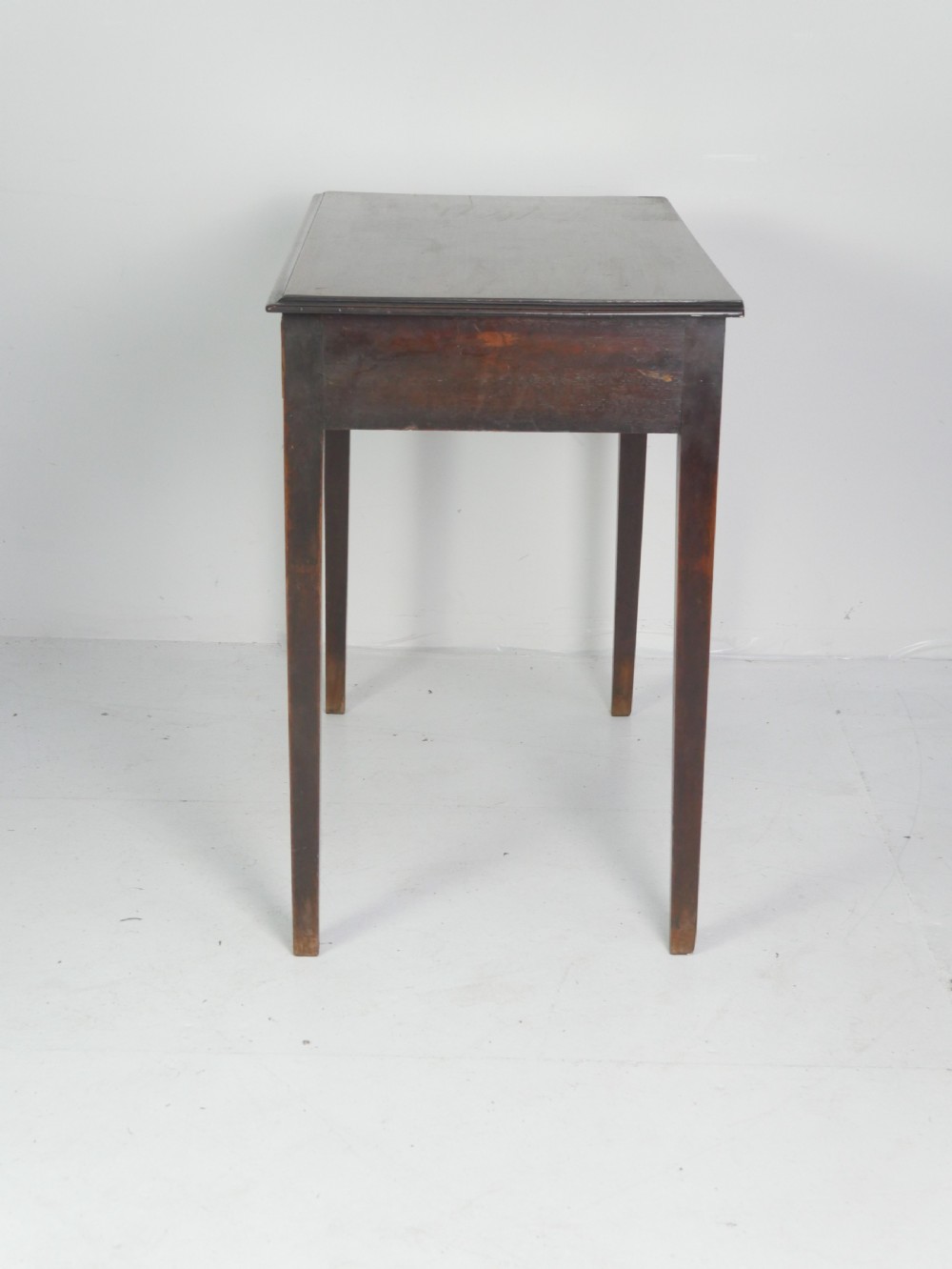 A dark mahogany Georgian side table featuring two front drawers with brass swan-neck handles and square tapered legs. View III
