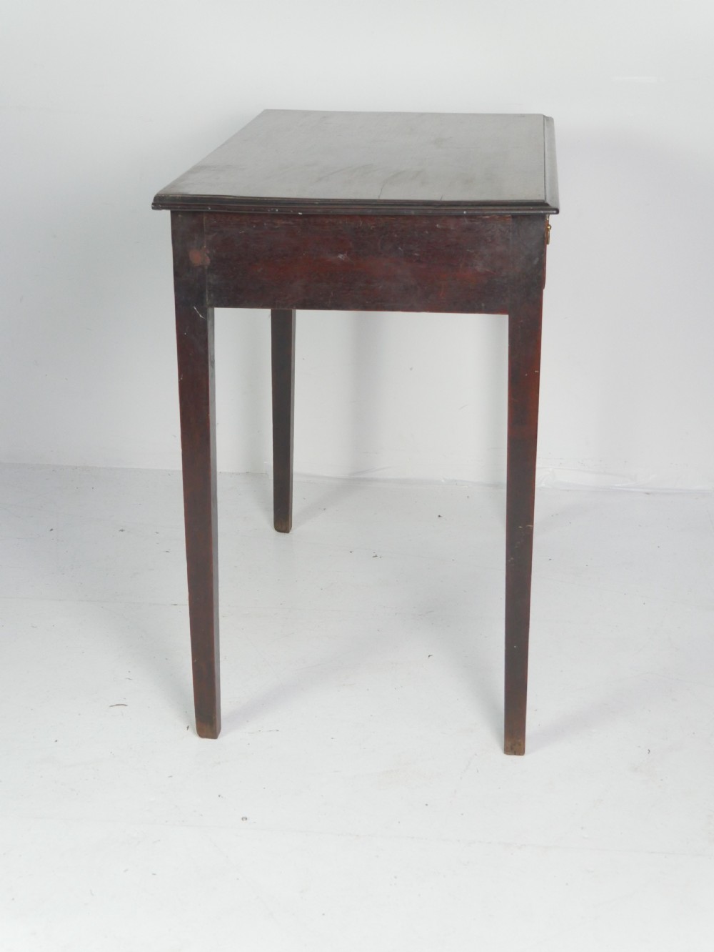 A dark mahogany Georgian side table featuring two front drawers with brass swan-neck handles and square tapered legs. View VI