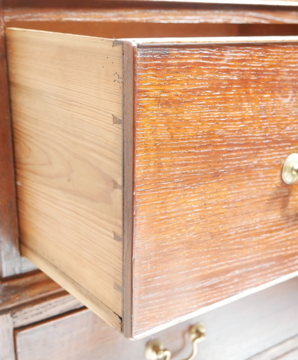 A tall Georgian oak chest on chest featuring brass swan-neck handles, keyhole escutcheons, and bracket feet. View VIII