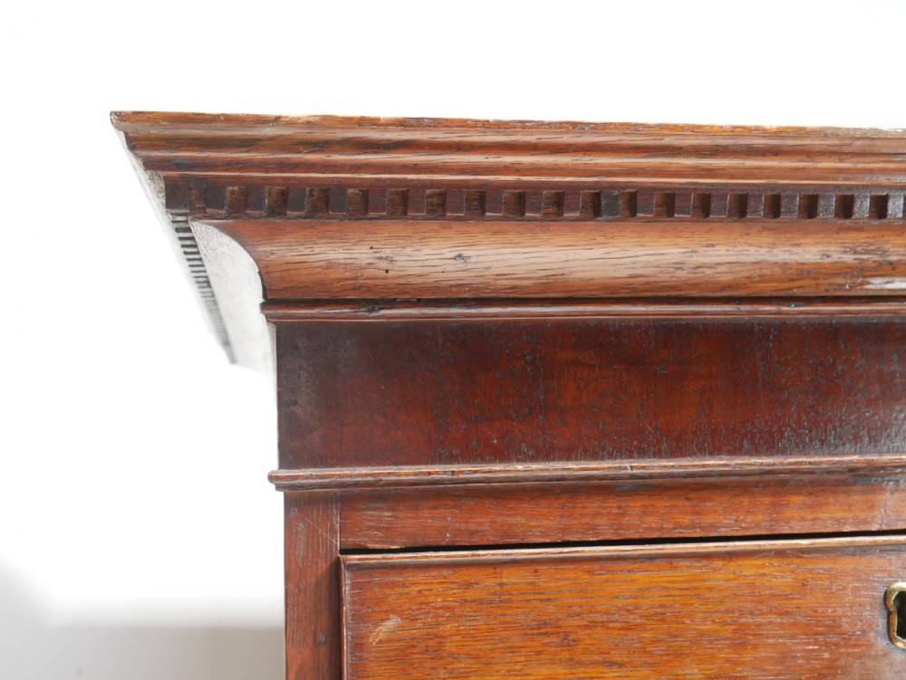 A tall Georgian oak chest on chest featuring brass swan-neck handles, keyhole escutcheons, and bracket feet. View X