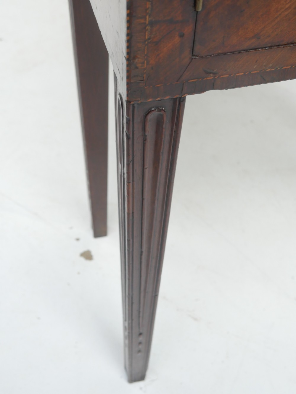 A Georgian mahogany sideboard featuring marquetry fan inlays, oval veneer door panels, a central drawer, and square tapered legs. View VII