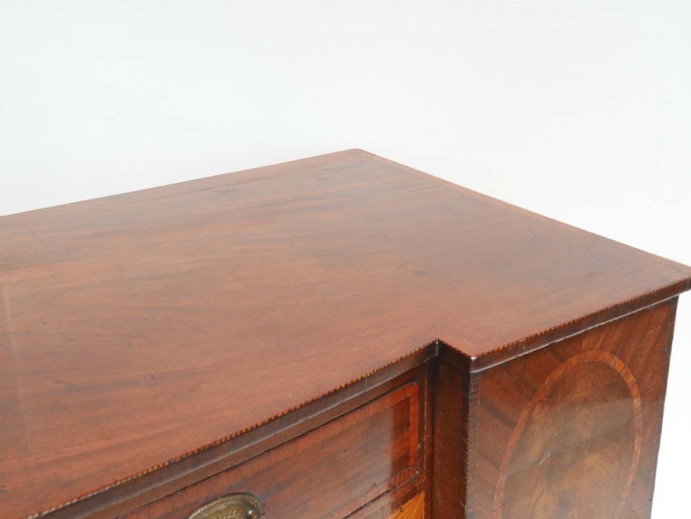 A Georgian mahogany sideboard featuring marquetry fan inlays, oval veneer door panels, a central drawer, and square tapered legs. View XIII