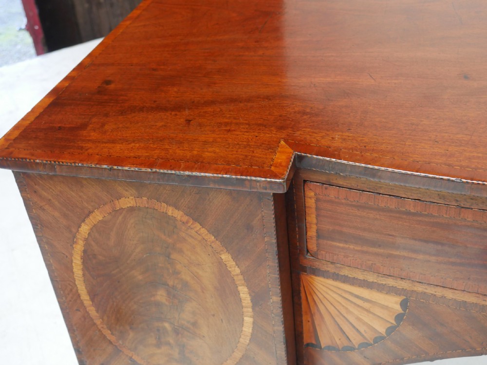 A Georgian mahogany sideboard featuring marquetry fan inlays, oval veneer door panels, a central drawer, and square tapered legs. View XV