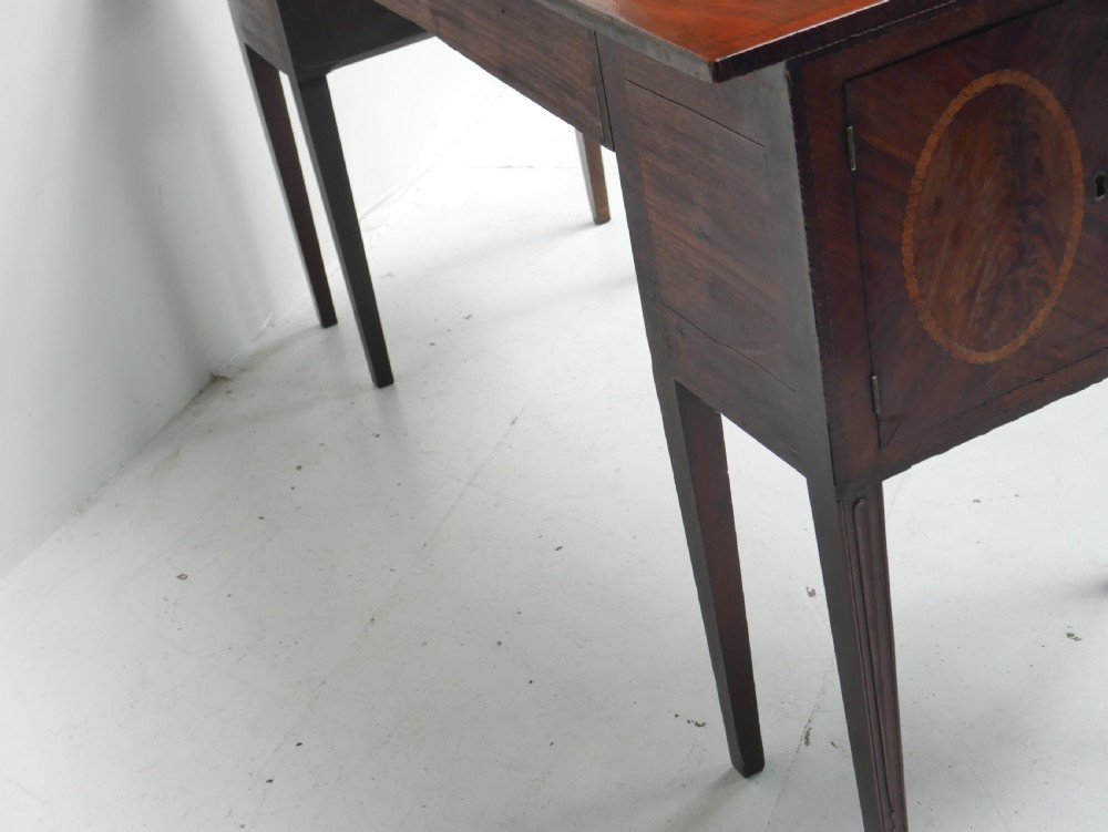 A Georgian mahogany sideboard featuring marquetry fan inlays, oval veneer door panels, a central drawer, and square tapered legs. View XVI