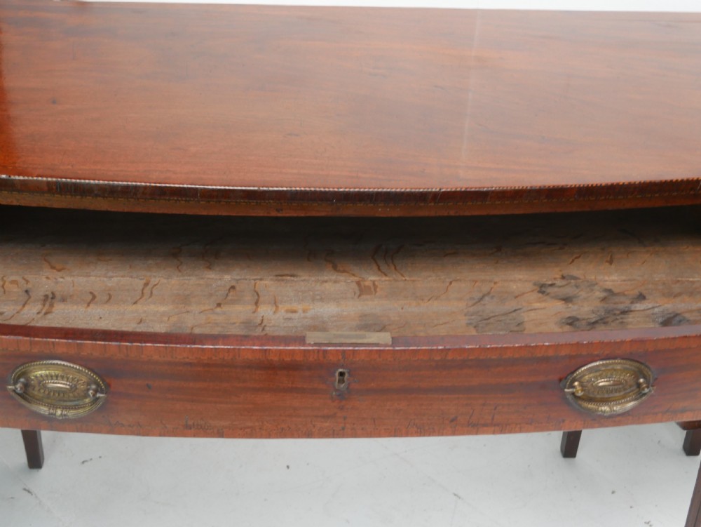 A Georgian mahogany sideboard featuring marquetry fan inlays, oval veneer door panels, a central drawer, and square tapered legs. View XVII