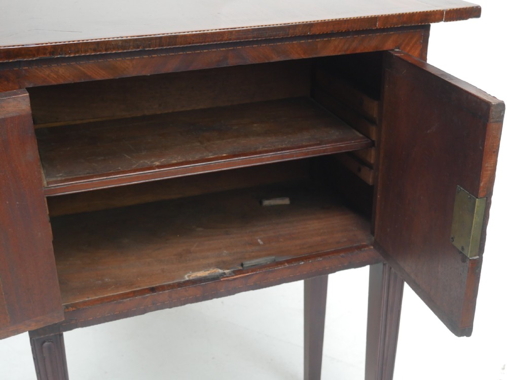 A Georgian mahogany sideboard featuring marquetry fan inlays, oval veneer door panels, a central drawer, and square tapered legs. View XVIII