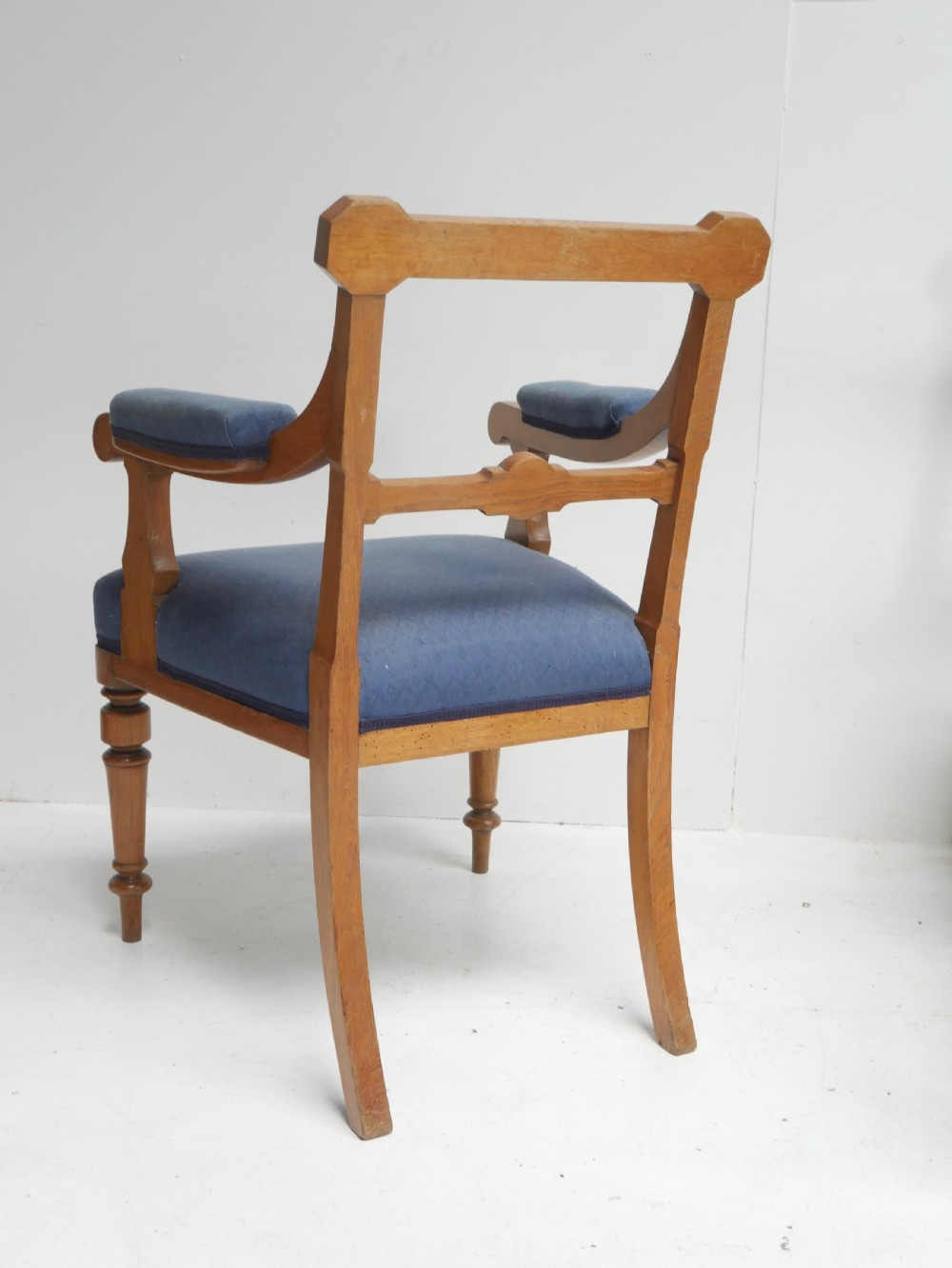 A set of twelve carved oak dining chairs with blue fabric upholstered seats and turned front legs. View VII