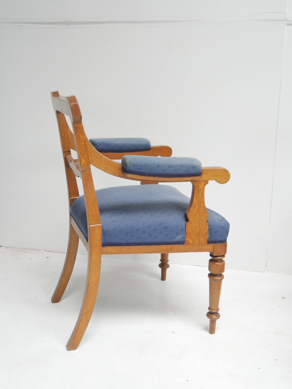 A set of twelve carved oak dining chairs with blue fabric upholstered seats and turned front legs. View VIII
