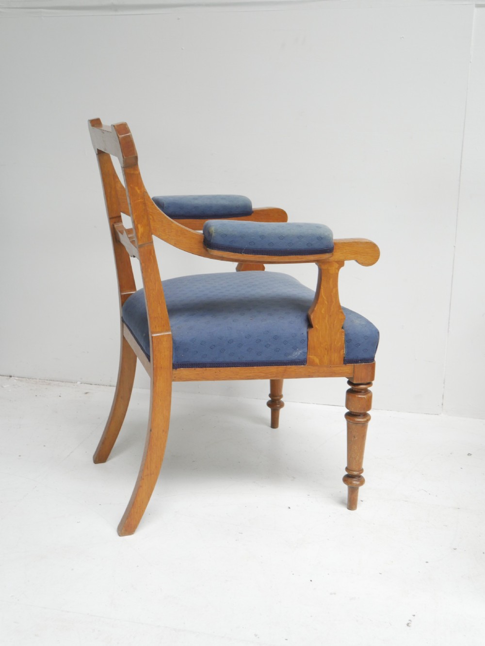 A set of twelve carved oak dining chairs with blue fabric upholstered seats and turned front legs. View IX