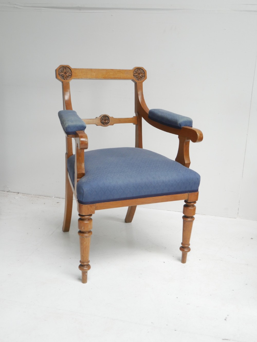 A set of twelve carved oak dining chairs with blue fabric upholstered seats and turned front legs. View X