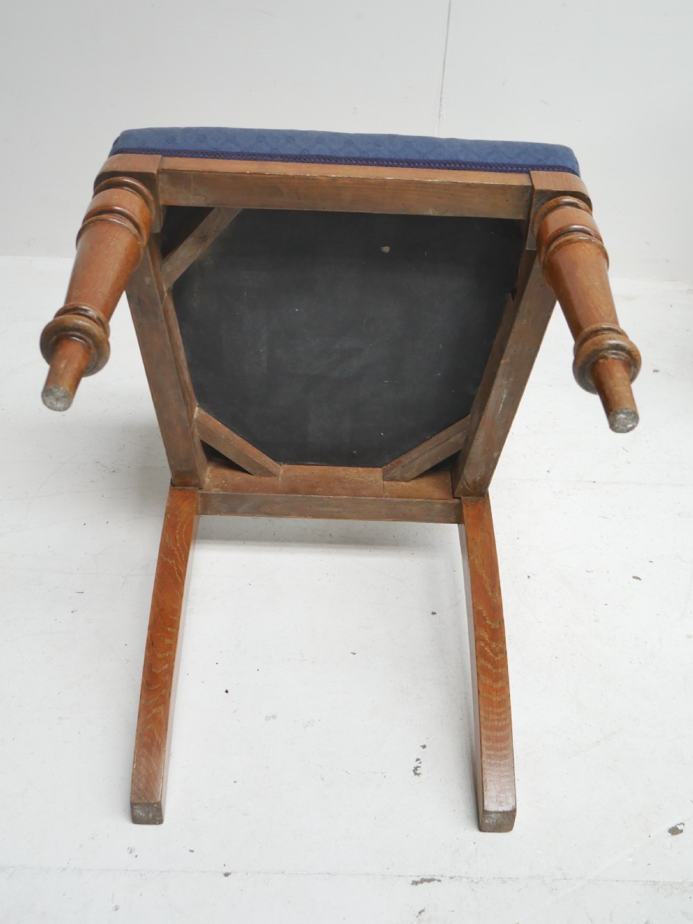 A set of twelve carved oak dining chairs with blue fabric upholstered seats and turned front legs. View XII