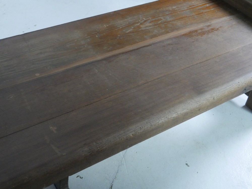 A long, rustic solid pine bench featuring raised side panels and sturdy central support legs. View VII