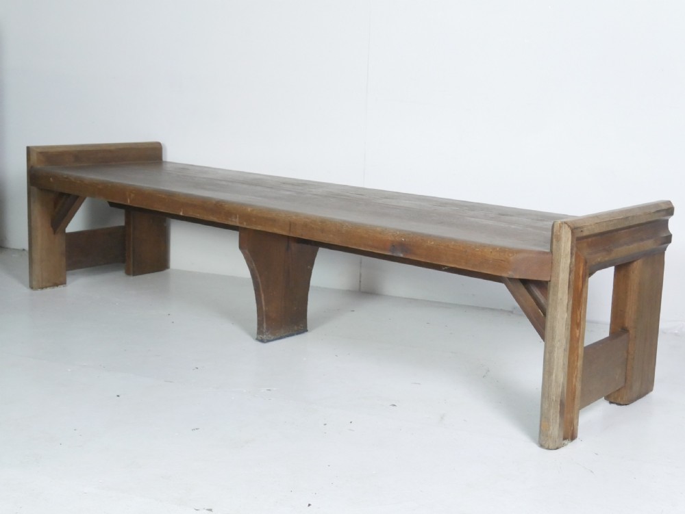 A long, rustic solid pine bench featuring raised side panels and sturdy central support legs. View X