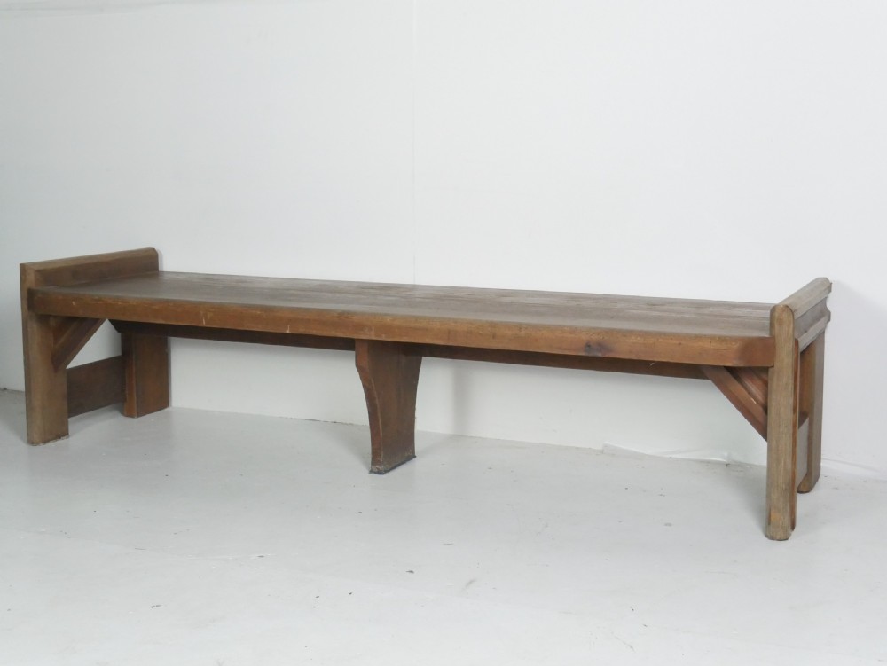 A long, rustic solid pine bench featuring raised side panels and sturdy central support legs. View XI