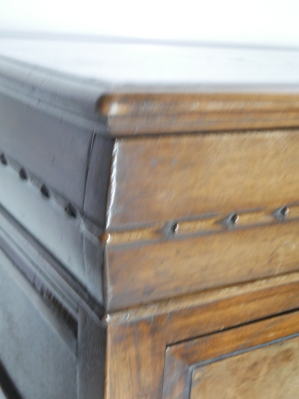 A tall wooden chest of drawers constructed from oak and walnut, featuring five drawers, panelled sides, turned legs with a stretcher base, and brass drop handles. View VIII