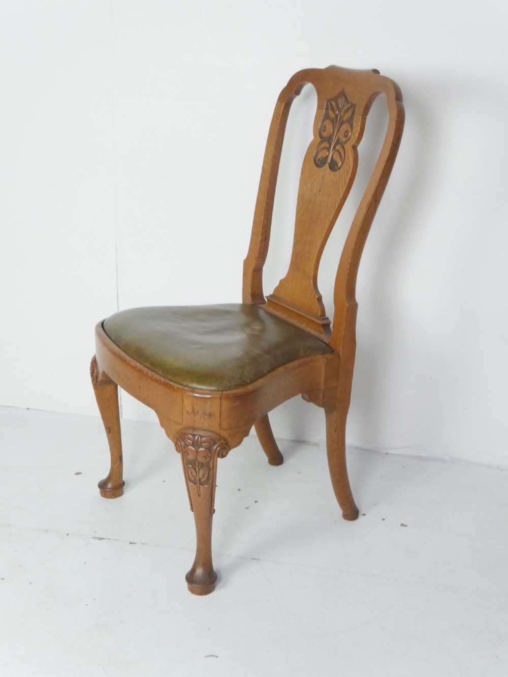 A large set of fourteen carved oak dining chairs featuring shaped back splats, drop-in upholstered seats, and cabriole front legs. View IV