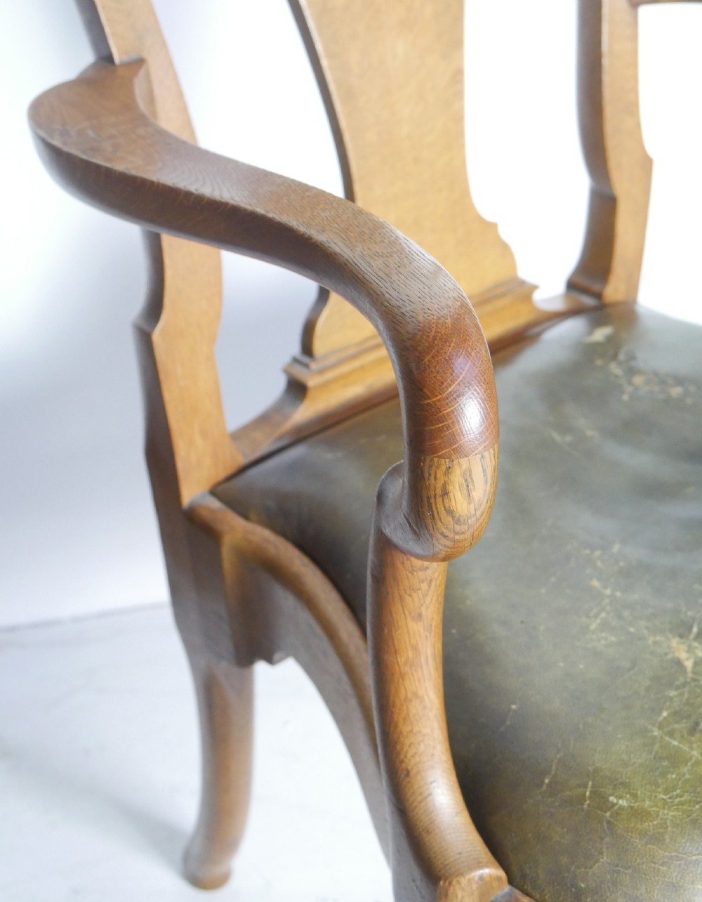 A large set of fourteen carved oak dining chairs featuring shaped back splats, drop-in upholstered seats, and cabriole front legs. View XIX