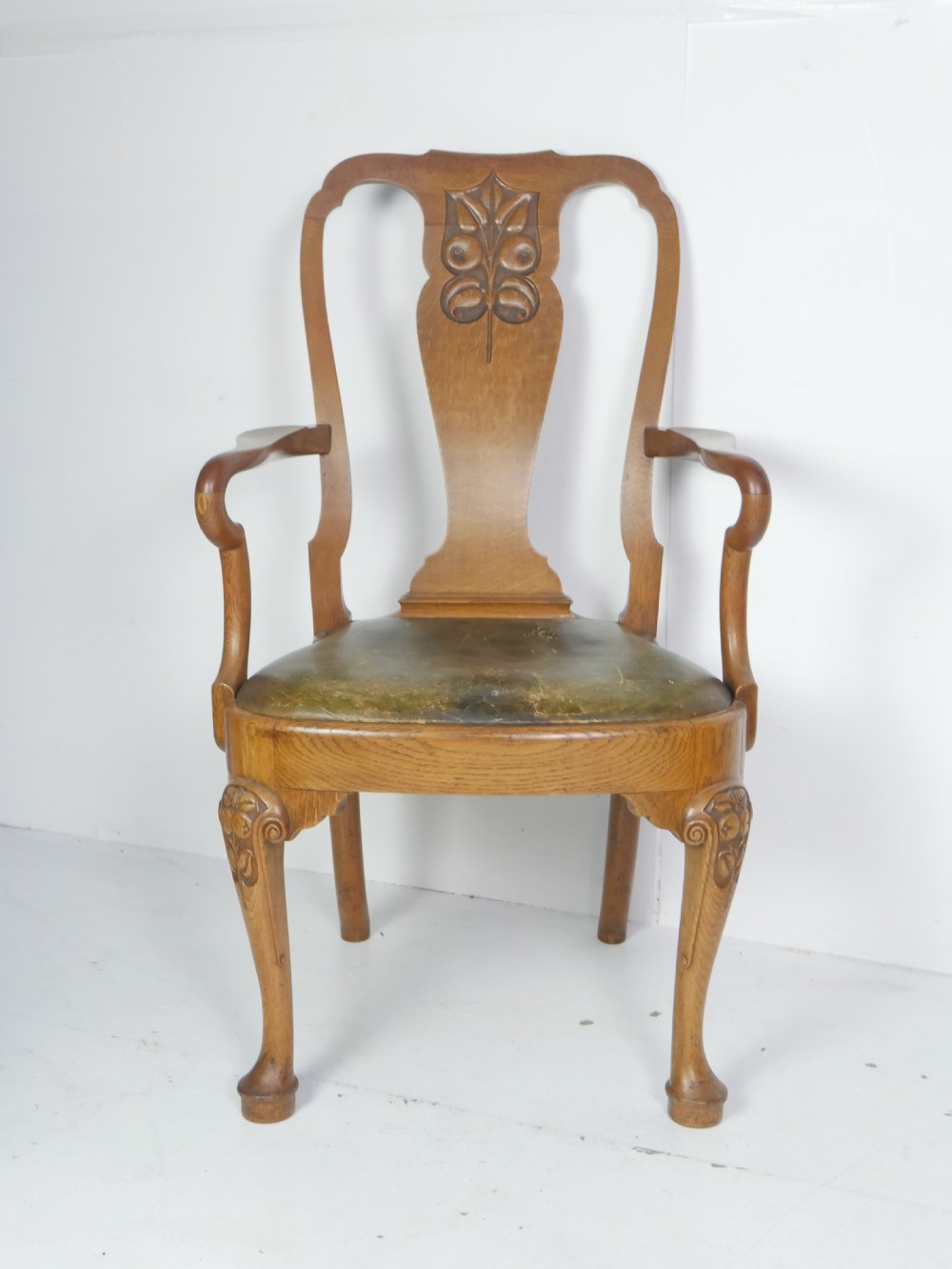 A large set of fourteen carved oak dining chairs featuring shaped back splats, drop-in upholstered seats, and cabriole front legs. View XIV