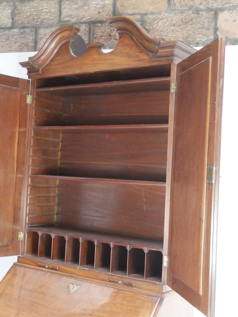 A tall Georgian mahogany bureau bookcase featuring a swan-neck pediment, glazed upper doors, a slant-front writing slope, four long drawers, and bracket feet. View III