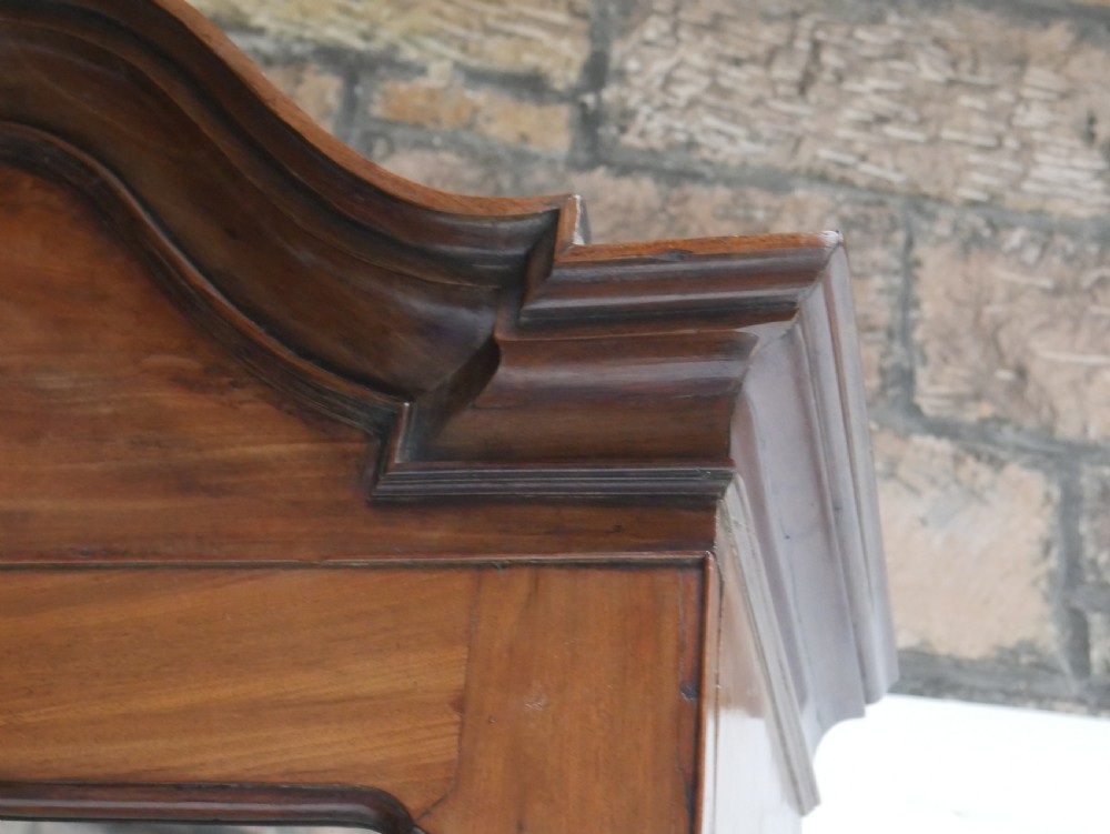 A tall Georgian mahogany bureau bookcase featuring a swan-neck pediment, glazed upper doors, a slant-front writing slope, four long drawers, and bracket feet. View XI