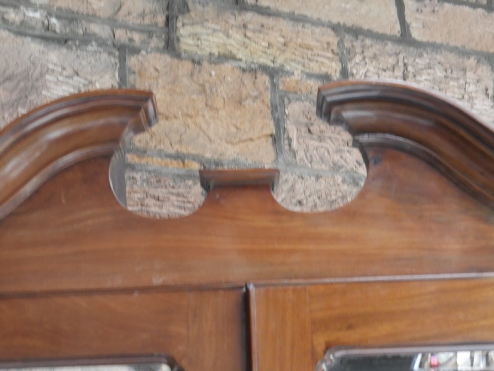 A tall Georgian mahogany bureau bookcase featuring a swan-neck pediment, glazed upper doors, a slant-front writing slope, four long drawers, and bracket feet. View XII