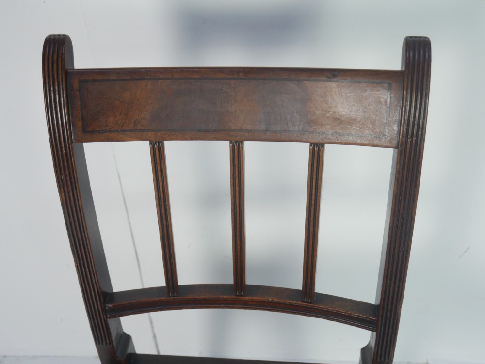 A set of six antique Georgian mahogany dining chairs with reeded vertical bar backs and embroidered needlepoint drop-in seats. View V