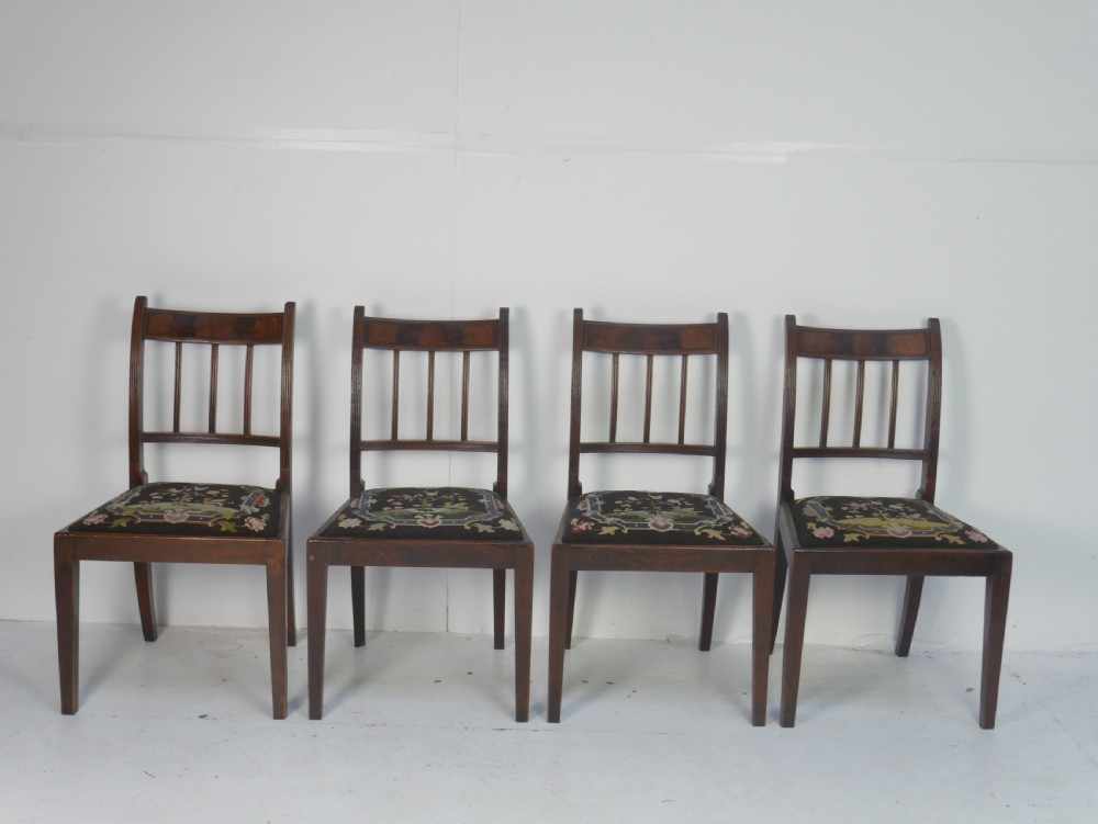 A set of six antique Georgian mahogany dining chairs with reeded vertical bar backs and embroidered needlepoint drop-in seats. View XII