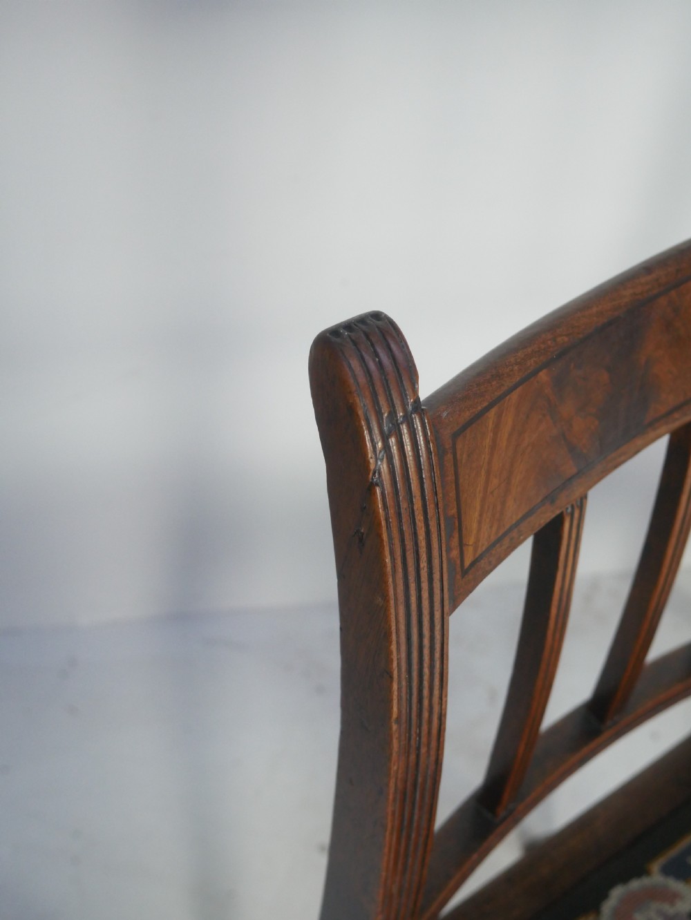 A set of six antique Georgian mahogany dining chairs with reeded vertical bar backs and embroidered needlepoint drop-in seats. View XIII