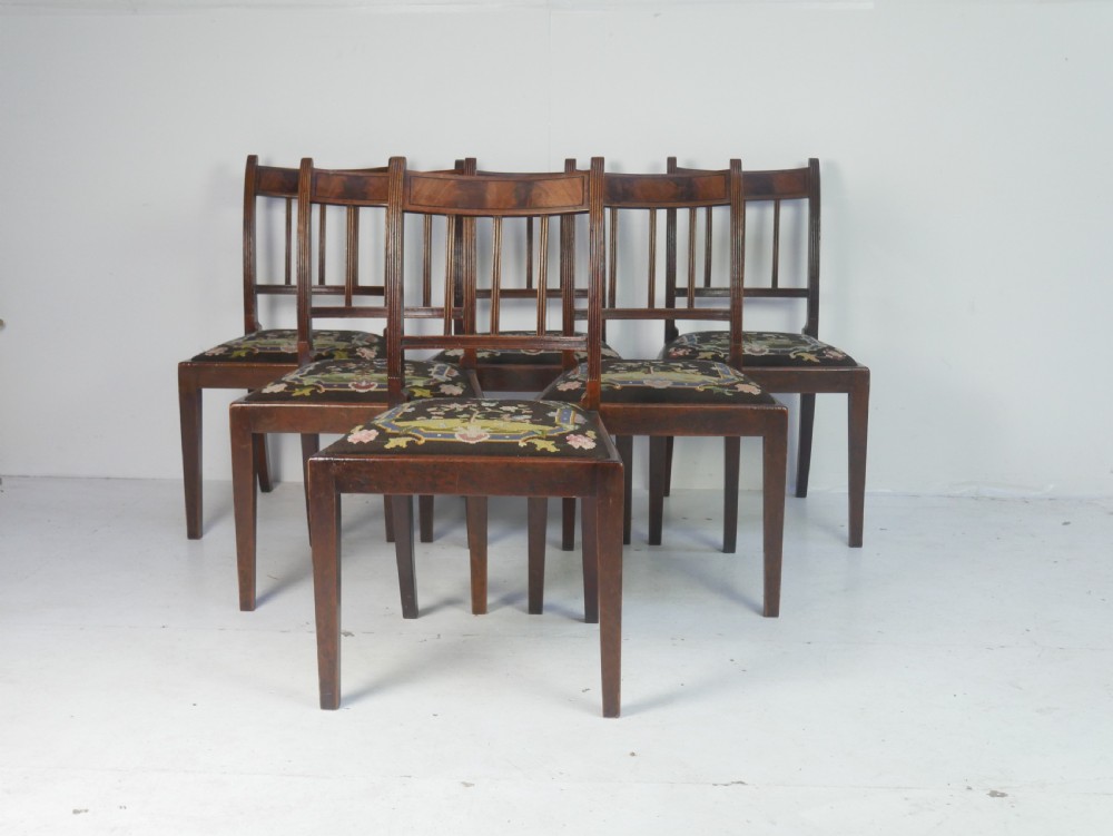 A set of six antique Georgian mahogany dining chairs with reeded vertical bar backs and embroidered needlepoint drop-in seats. View XIV