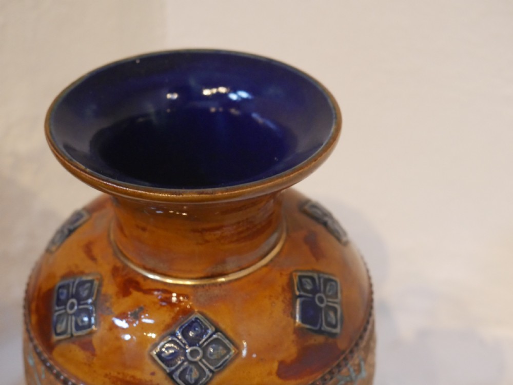 A pair of antique Royal Doulton stoneware vases featuring caramel brown glazing, white floral decorations, and blue foliate accents around the base. View III