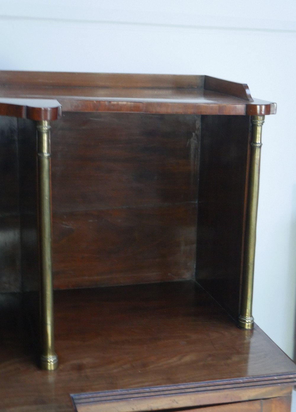 A Georgian mahogany chiffonier featuring an upper display shelf supported by brass columns above panelled cupboard doors and turned legs. View III