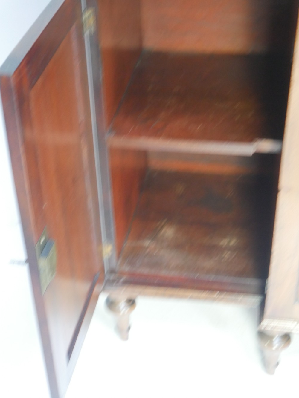 A Georgian mahogany chiffonier featuring an upper display shelf supported by brass columns above panelled cupboard doors and turned legs. View VIII