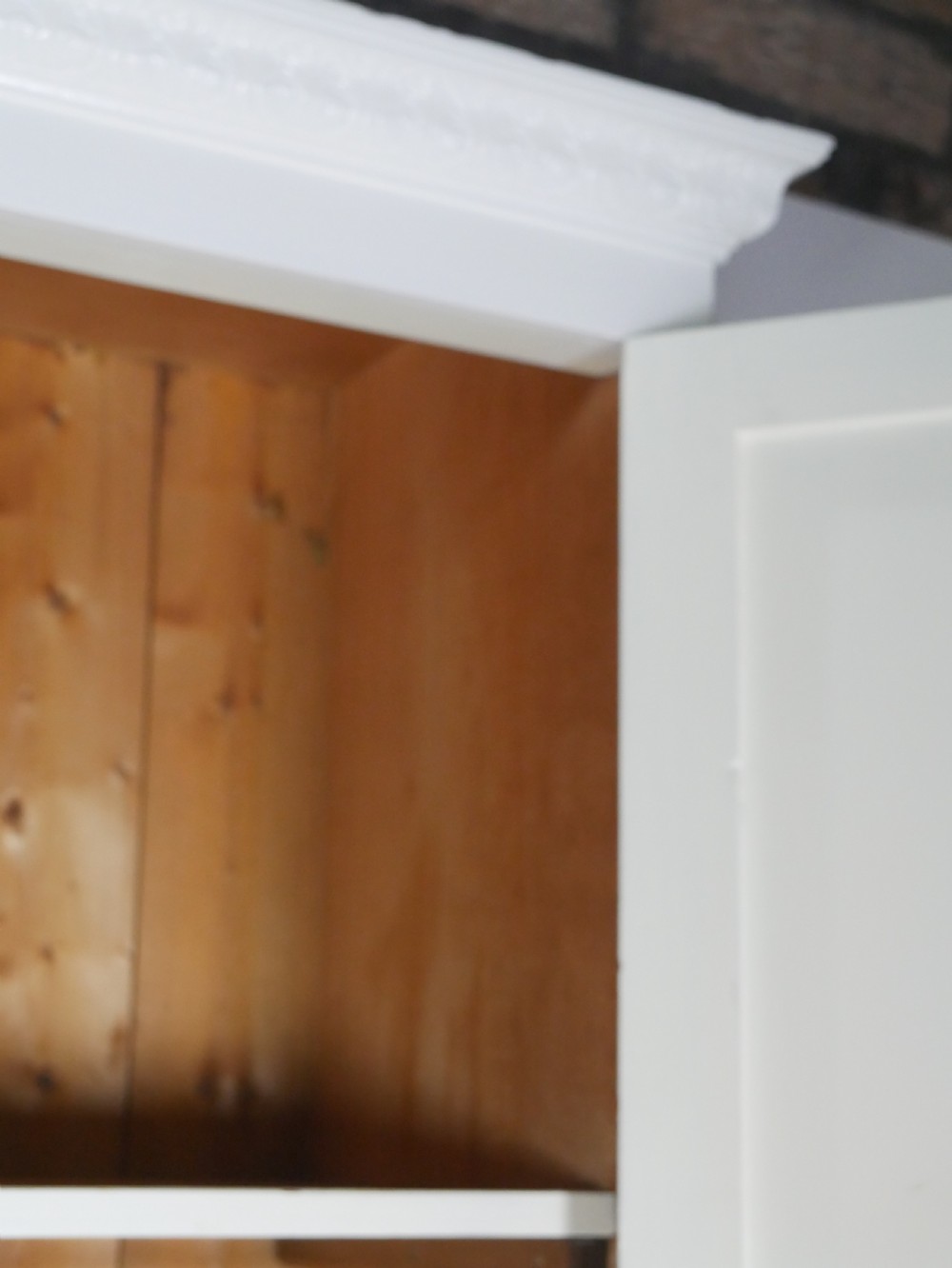 A large double-door white painted wooden wardrobe with open doors revealing a natural pine interior featuring a hanging rail and top shelf. View IV