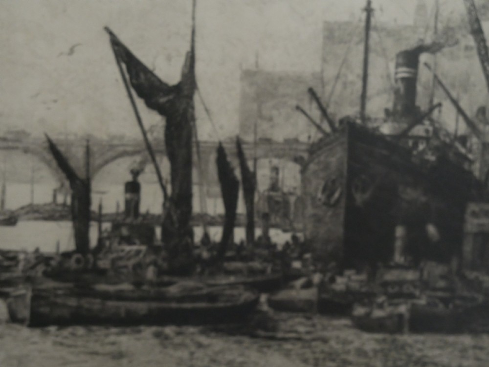 A framed monochrome etching depicting ships and barges on the River Thames with London Bridge in the background. View VI