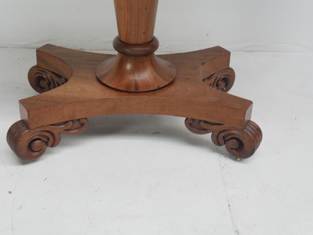 A nineteenth-century mahogany turn-over table with a pedestal stem, carved scroll brackets, and a quadform base on scroll feet. View III