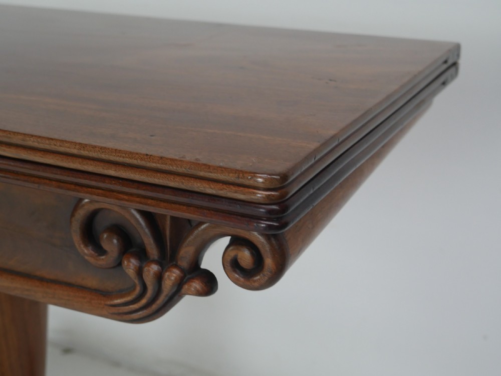 A nineteenth-century mahogany turn-over table with a pedestal stem, carved scroll brackets, and a quadform base on scroll feet. View V