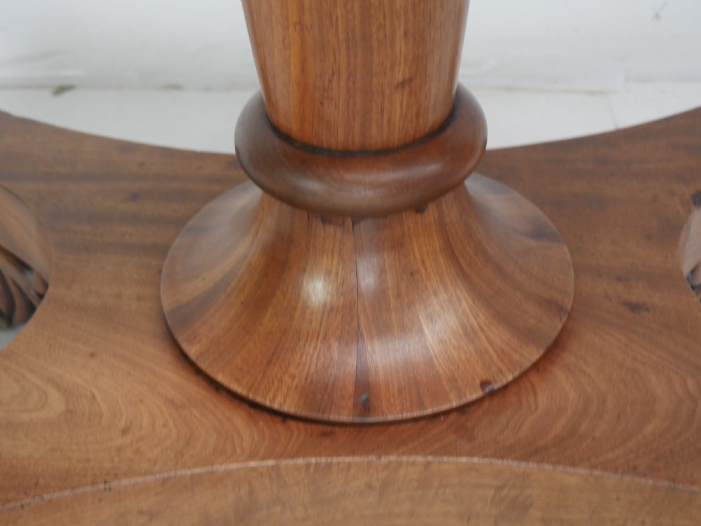A nineteenth-century mahogany turn-over table with a pedestal stem, carved scroll brackets, and a quadform base on scroll feet. View VI