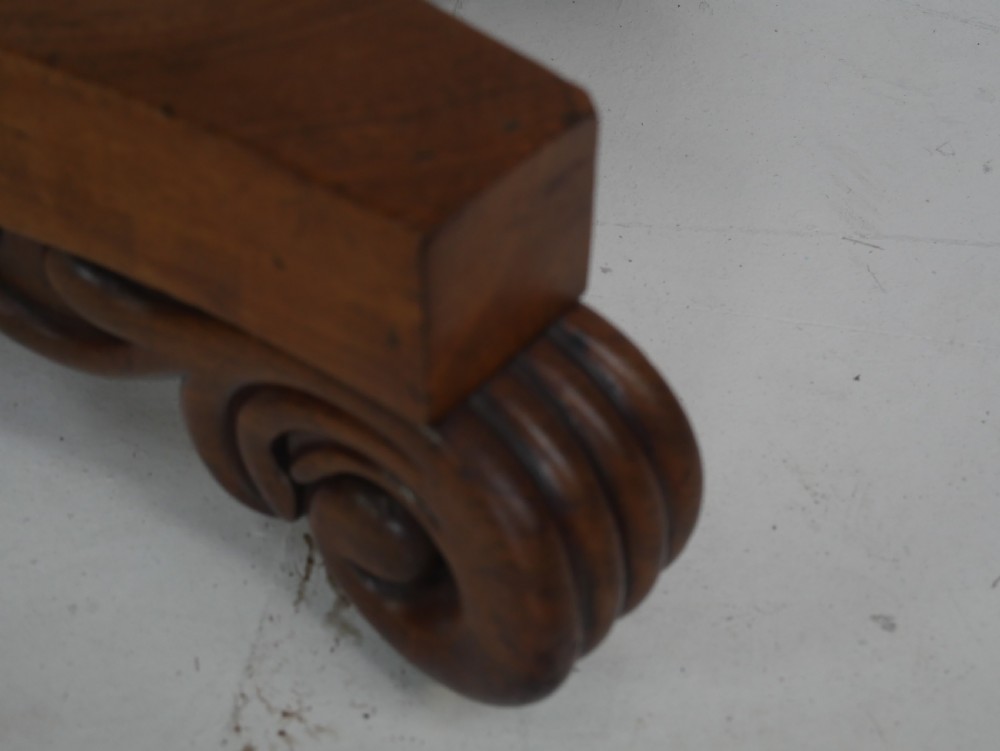 A nineteenth-century mahogany turn-over table with a pedestal stem, carved scroll brackets, and a quadform base on scroll feet. View VII