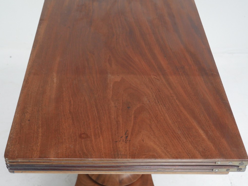 A nineteenth-century mahogany turn-over table with a pedestal stem, carved scroll brackets, and a quadform base on scroll feet. View IX