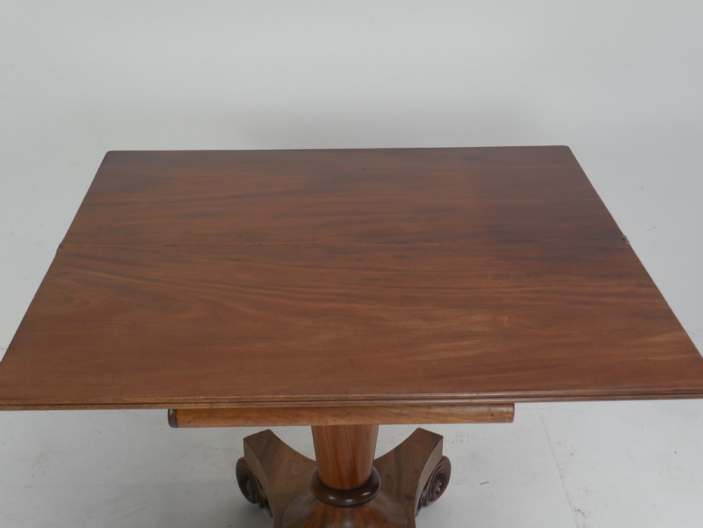 A nineteenth-century mahogany turn-over table with a pedestal stem, carved scroll brackets, and a quadform base on scroll feet. View XI