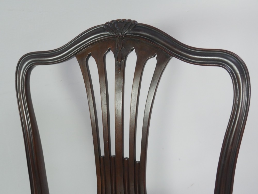 A set of eight mahogany Chippendale style dining chairs featuring pierced splat backs, square legs with stretchers, and burgundy leather seats trimmed with brass studs. View VI