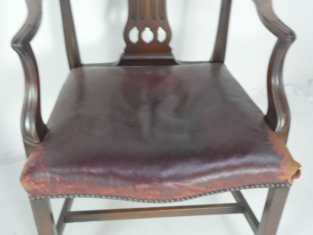 A set of eight mahogany Chippendale style dining chairs featuring pierced splat backs, square legs with stretchers, and burgundy leather seats trimmed with brass studs. View XIII